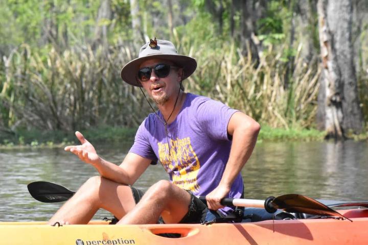 a man riding on the back of a boat in a body of water